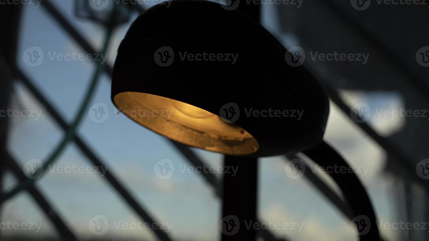 Table lamp in room. Old lamp shines indoors. Interior details. photo