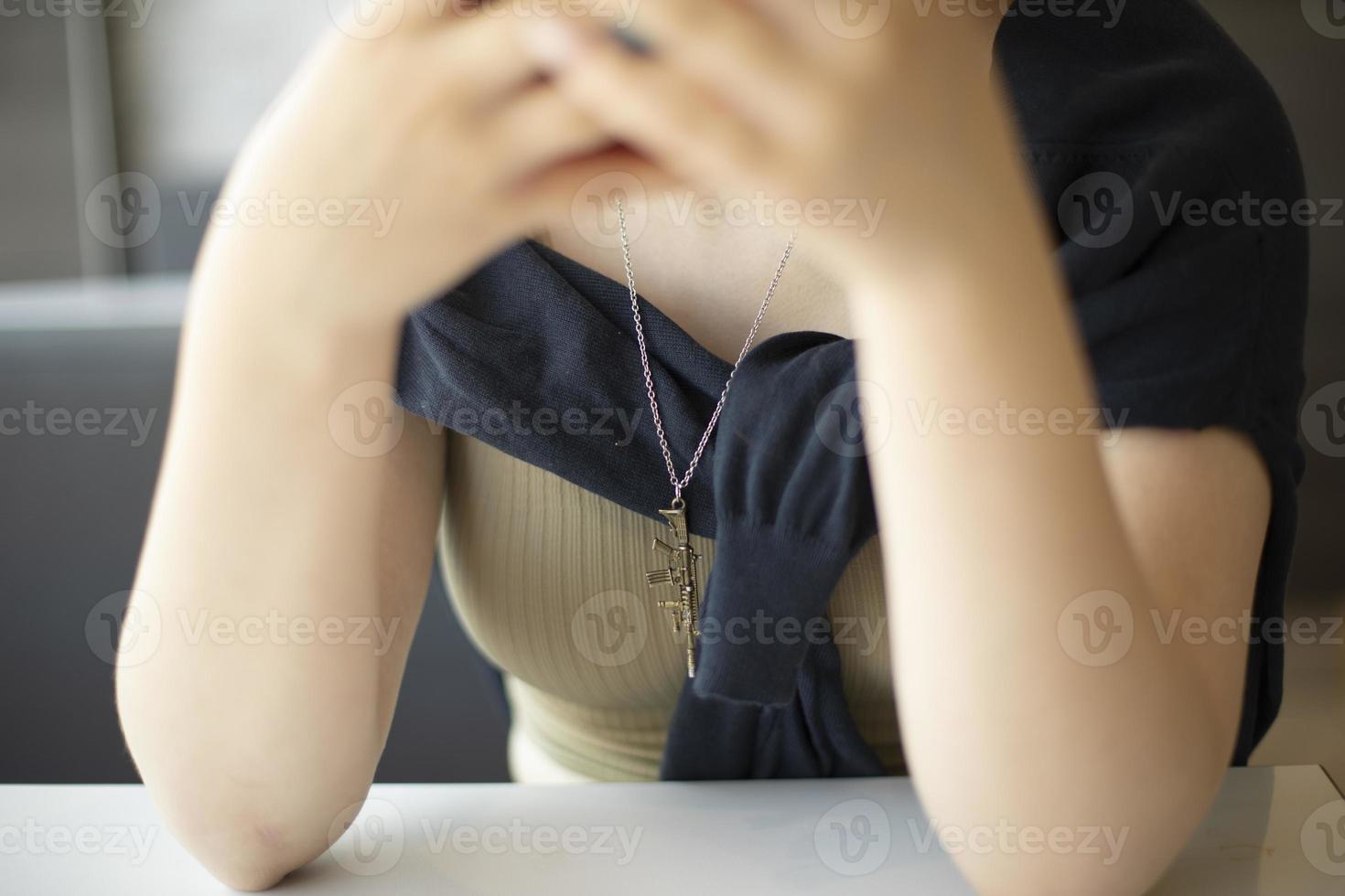 Girl sitting at table. Elbows on table. People waiting. photo