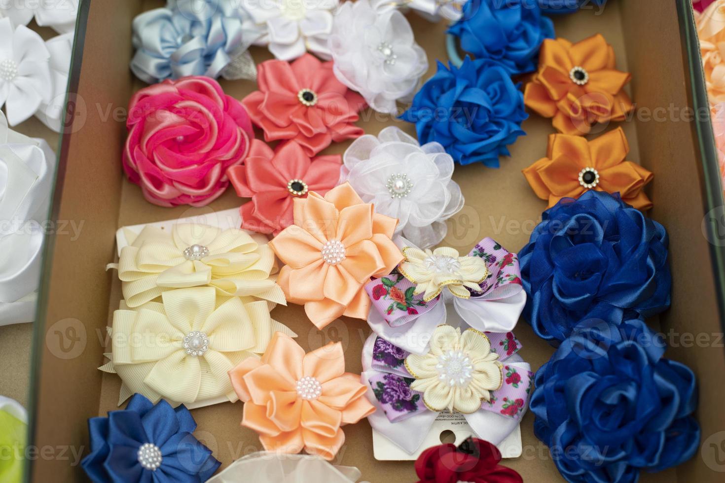 Flowers made of hair fabric. Hair clips of different colors. Fabric products for decoration. photo
