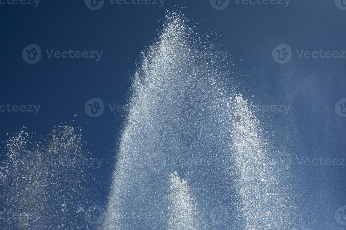 Jets of water against sky. Fountain in city. Details of fountain on street. photo