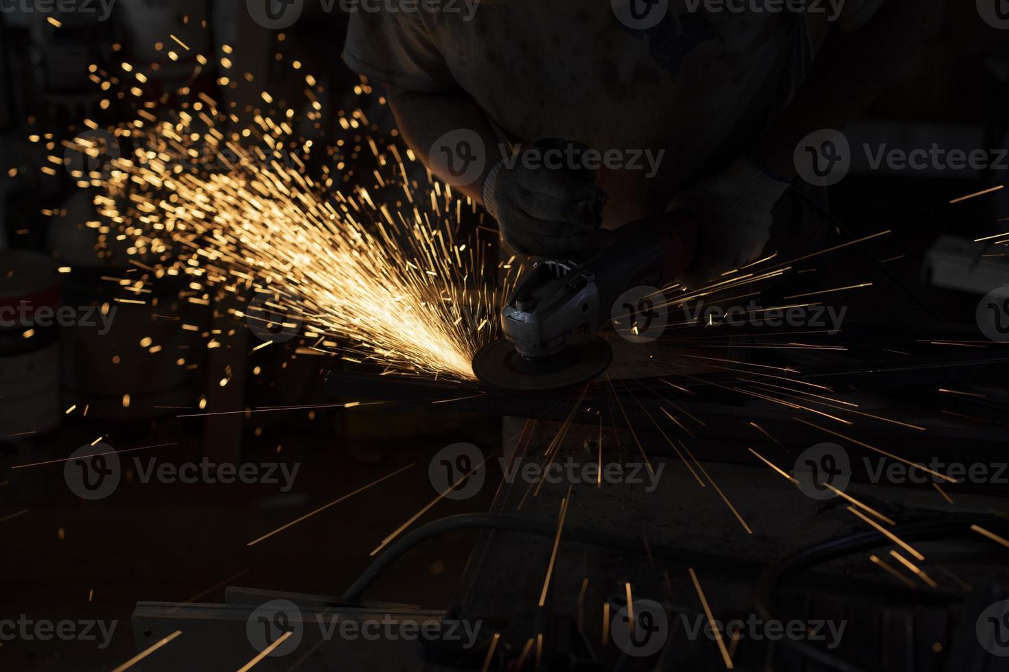 Sparks from steel. Metal sawing. Lights in dark. Work in garage. photo