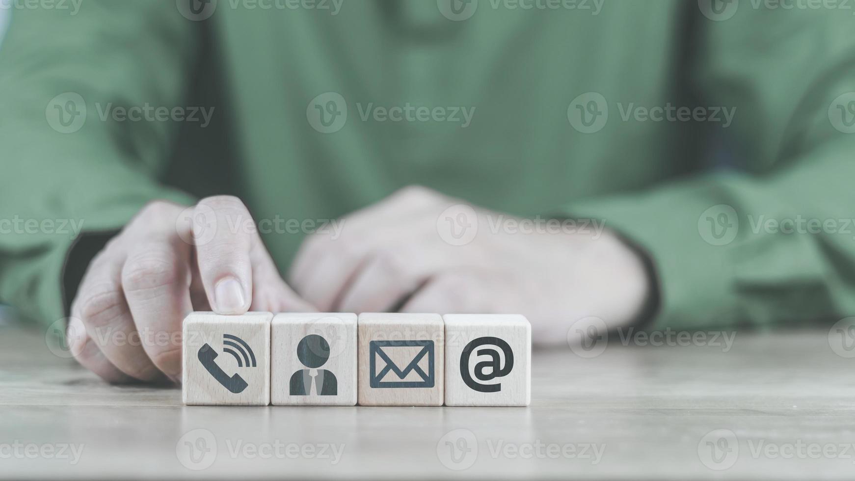 Customer support hotline Contact us concept cube wood showing icons, smartphones, message boxes, addresses and letters, conveys the contact channel. with the service online support for advice photo