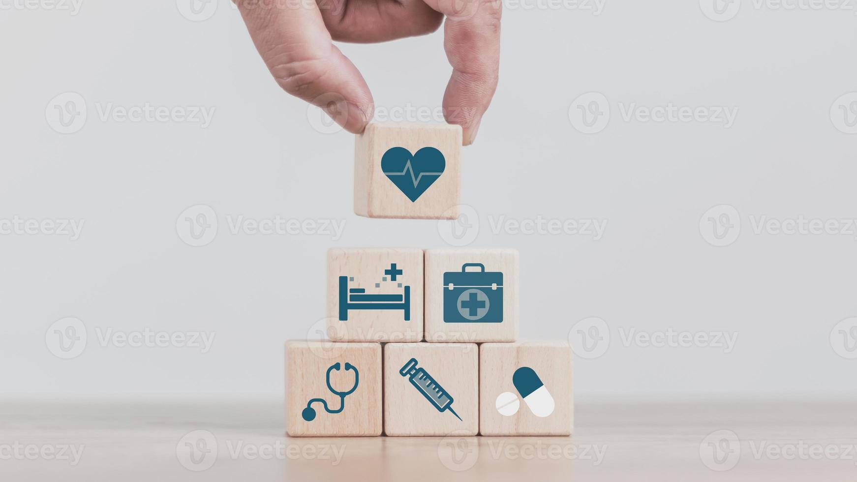 insurance concept, a man's hand is building a cube wood to show the decision about life insurance to plan the future for themselves and their families on money, health and tax breaks. photo