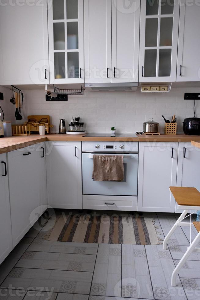 cocina blanca y acogedora en estilo loft scandi. interior de la casa, diseño de comedor, horno, vitrocerámica, mesa, muebles de cocina foto