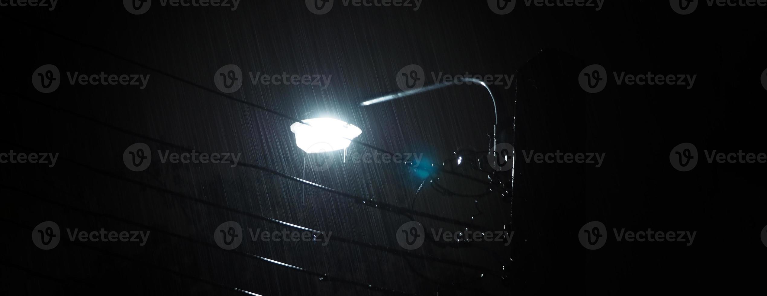Raining Night and light. Rain Drops Falling in night at Bangkok Thailand in August raining season. photo