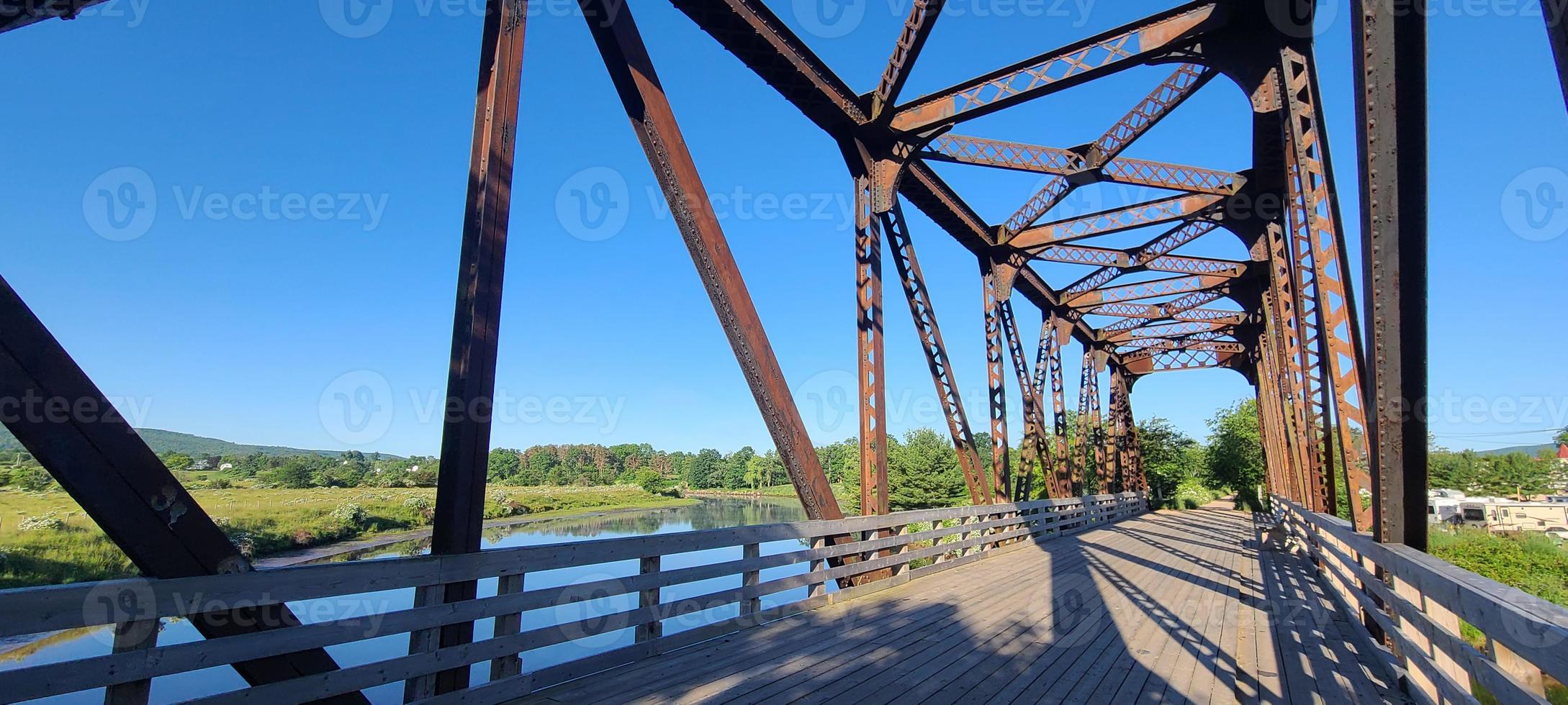 a old railway Trussell with a board walk and a blue sky photo