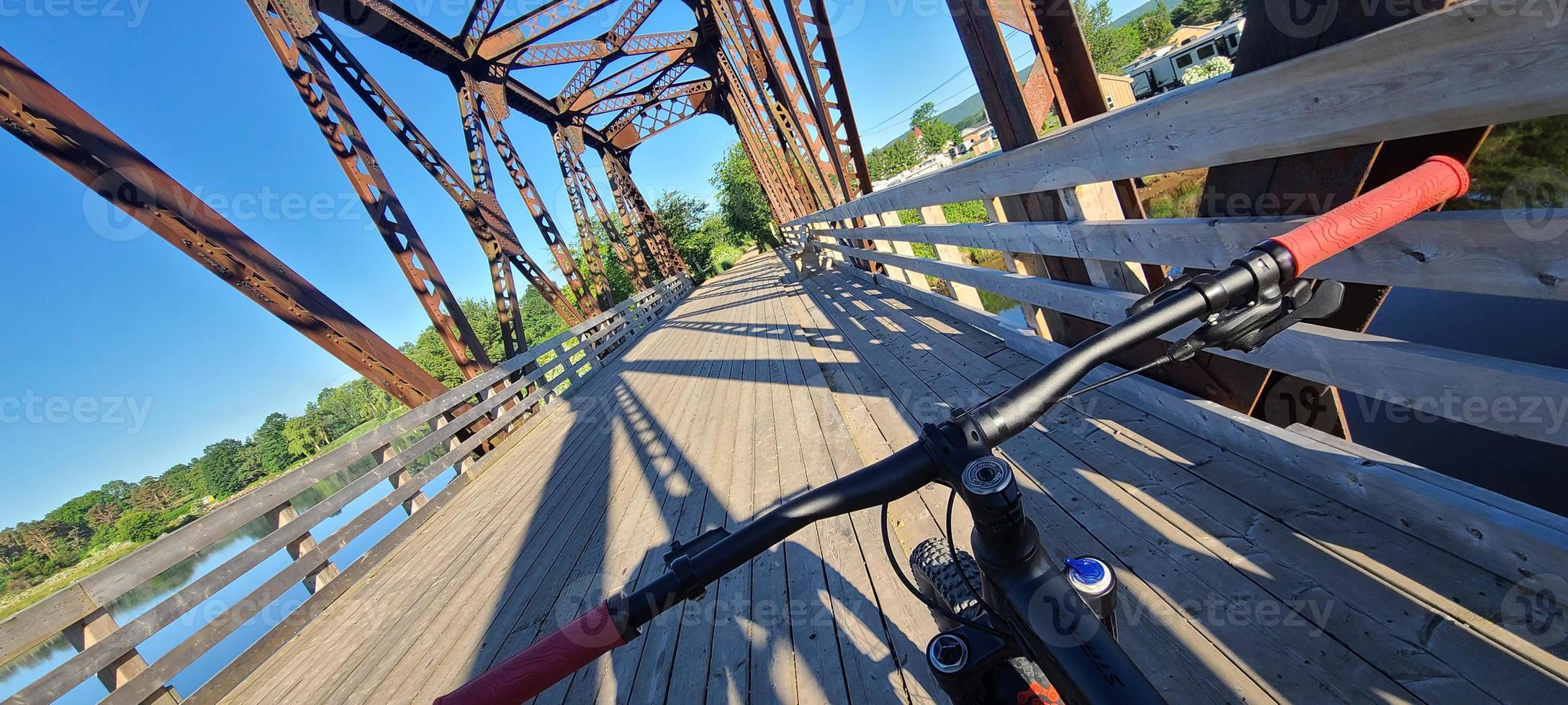 una bicicleta de montaña de los ciclistas prospectivos en un puente ferroviario foto