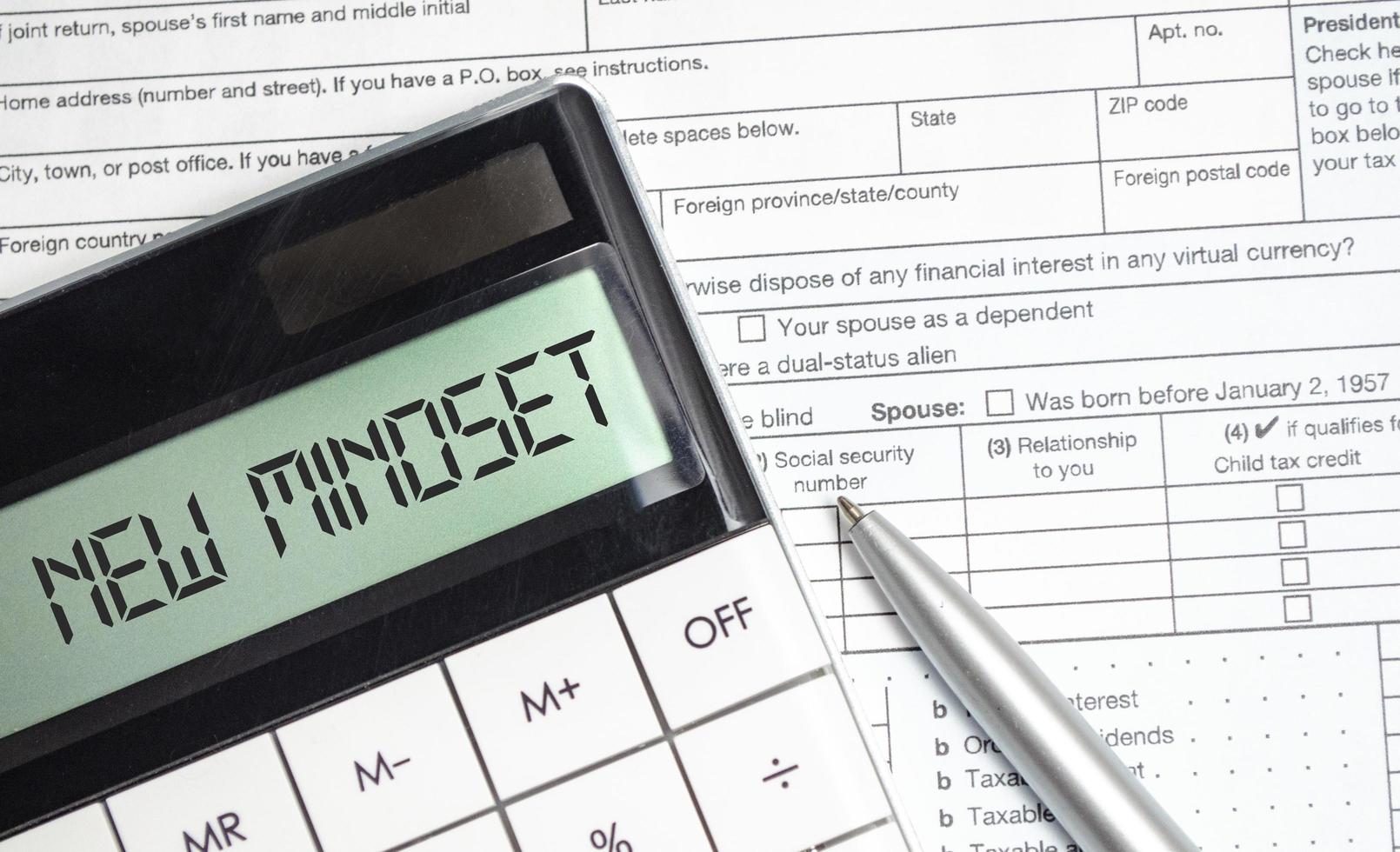 new mindset words on calculator display and tax forms photo