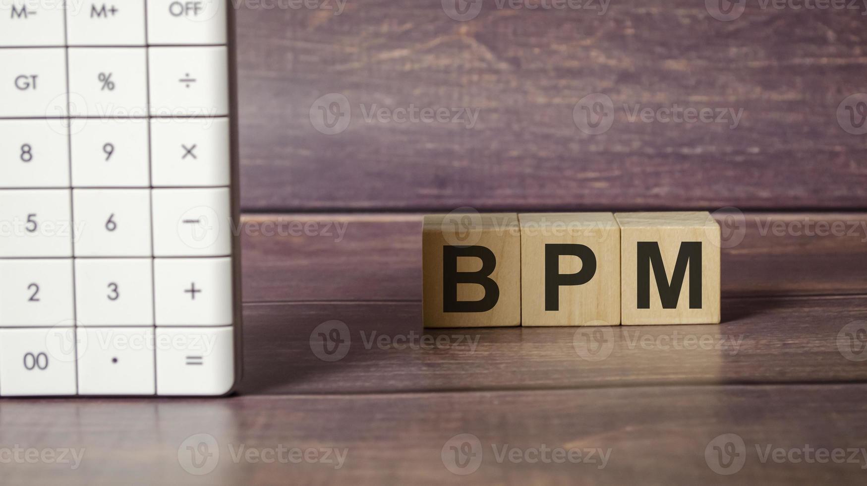 BPM Business Process Management on wooden blocks and calculator photo