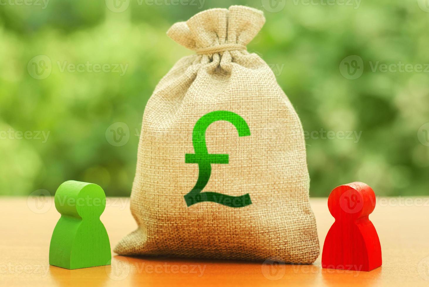 Money bag with money pound sterling GBP symbol and two people figures. Business Investment and lending, leasing. Business relationship. Dispute solution between two businessmen. division of property photo
