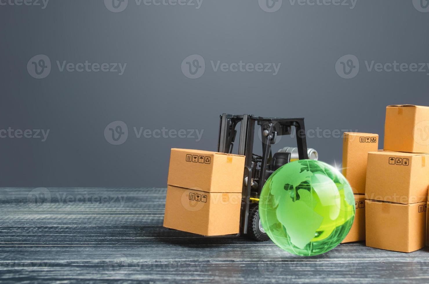 Green glass globe and forklift truck with cardboard boxes. Distribution and trade exchange goods around the world, retail and sales. Global business, import, export. Economic relations. Freight photo