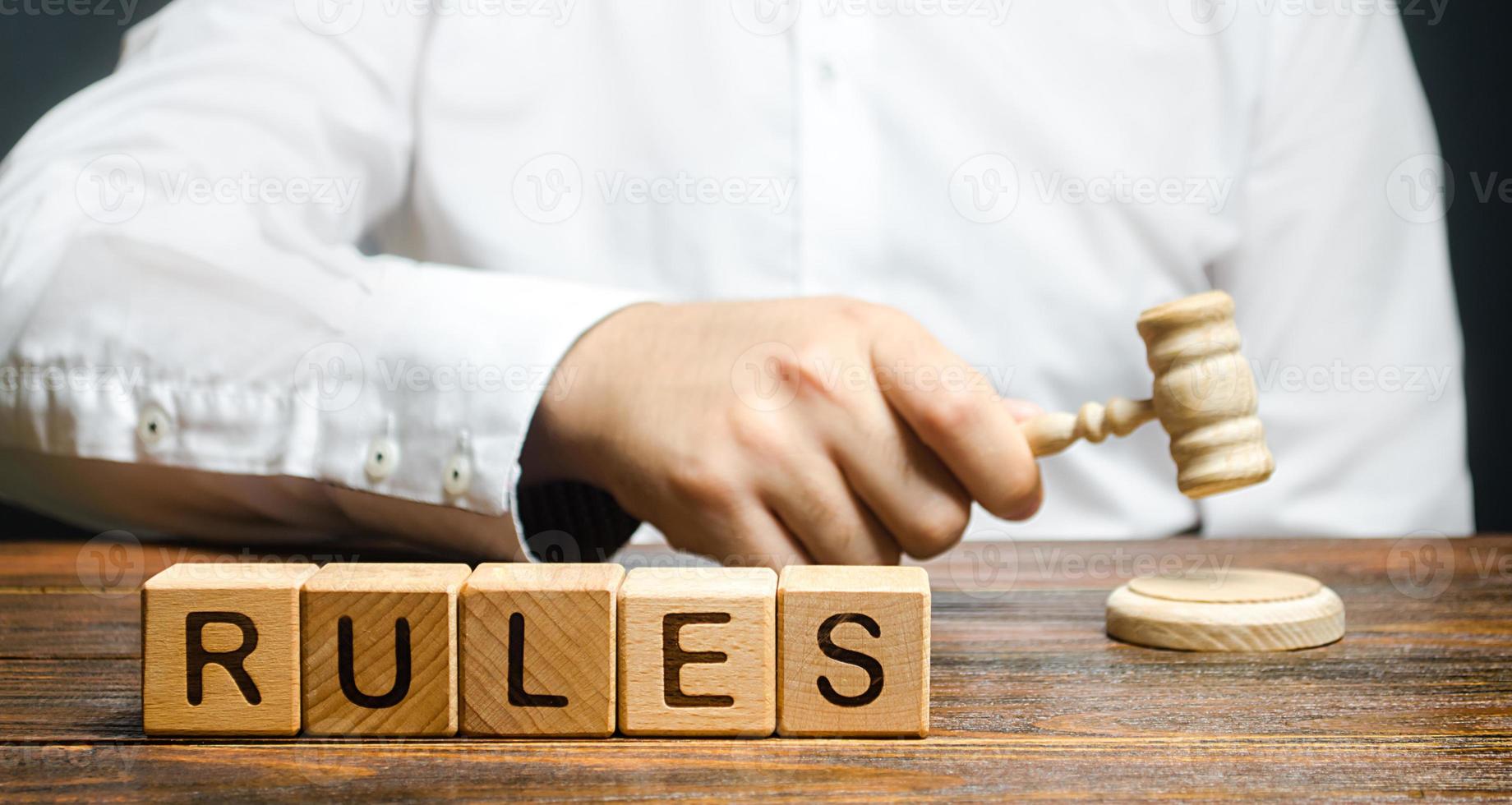 A man knocks a hammer publishes new rules and laws. Setting clear rule and restrictions. Leadership and discipline. Authoritarianism, tight control framework. Norms and laws in society, state photo