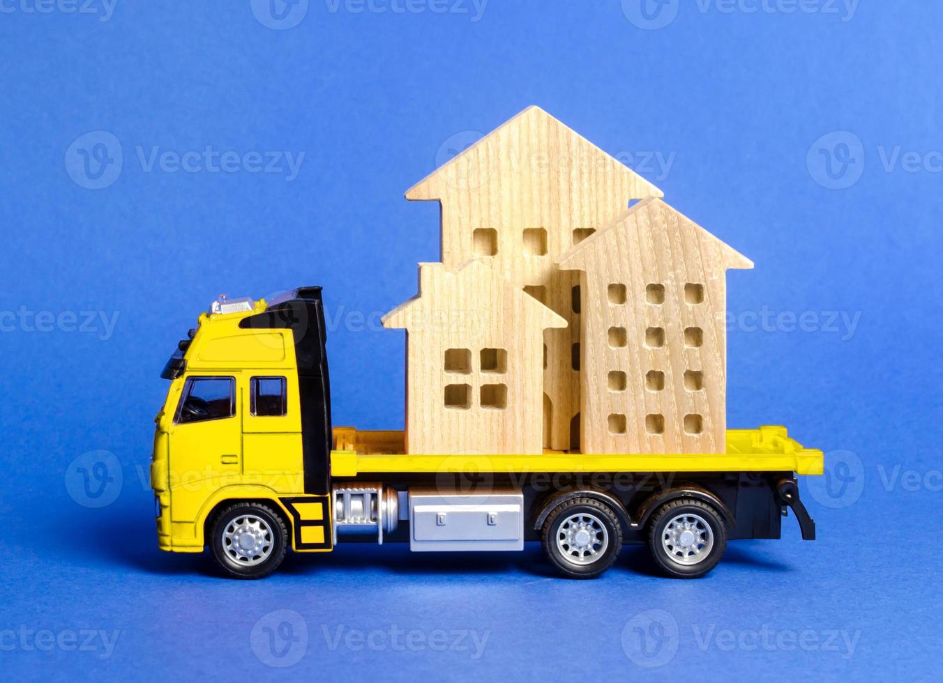 A cargo truck transports houses. Concept of transportation and cargo shipping, moving company. Construction of new houses and objects. Logistics and supply. Move entire buildings photo