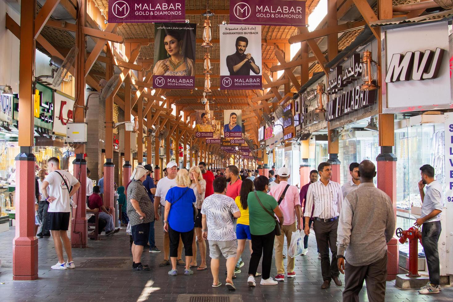 Dubai, UAE, 2022  - people tourist walk sightseeing old gold souk in old Dubai. Famous attraction and landmark in UAE for buying gold and visiting photo