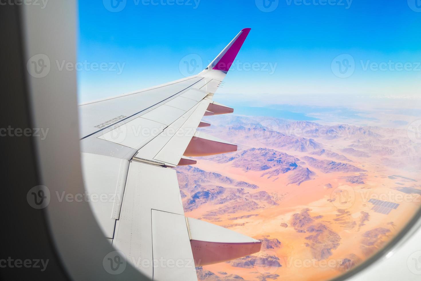 Airplane interior with window view of beautiful textures and landscape of wadi rum desert in Jordan middle east. Concept of travel and air transportation. Visit Jordan concept photo