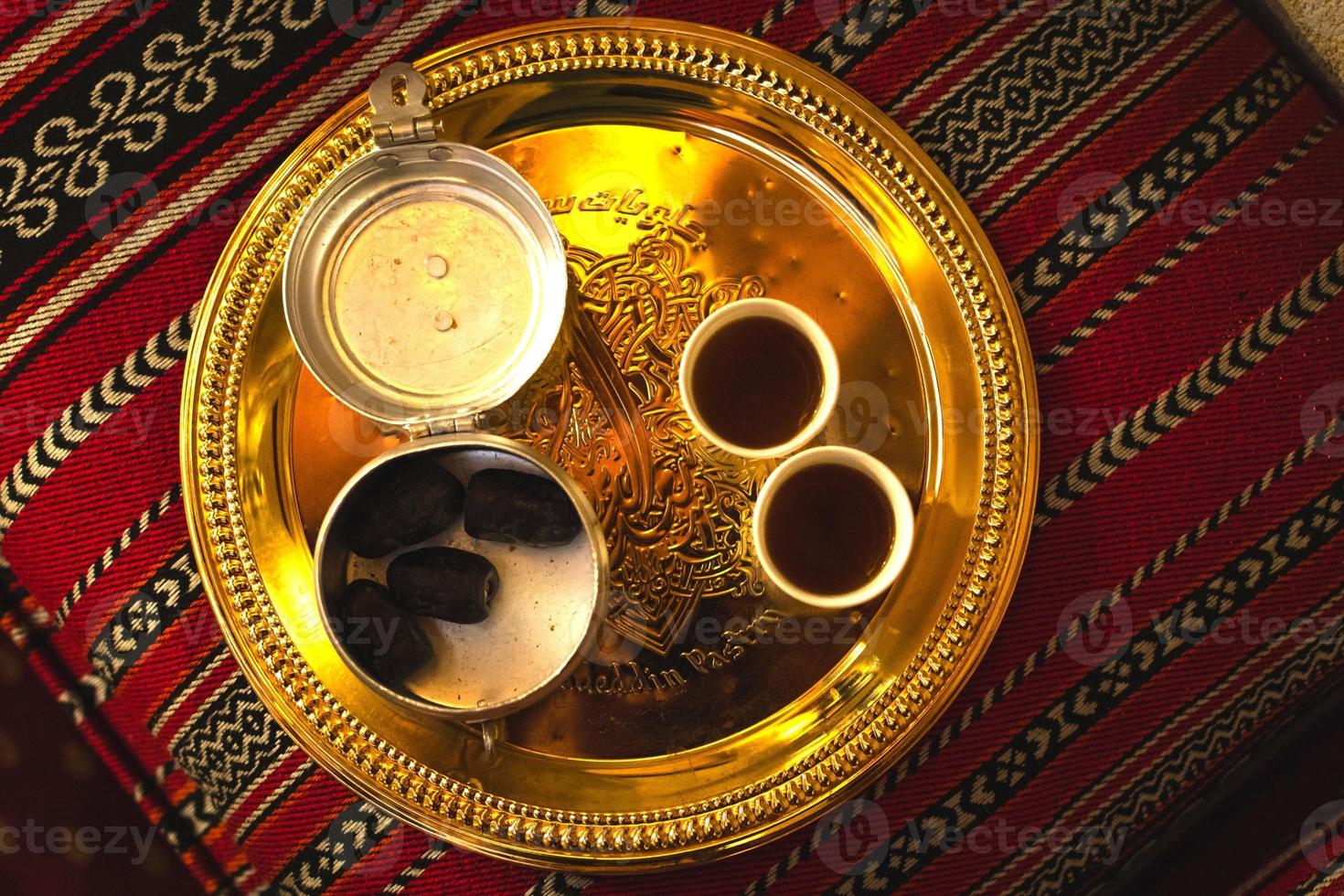 Dubai, UAE, 2022 - Top view coffee set up on silver plate of two cups and dates in bowl in coffee museum in Dubai photo