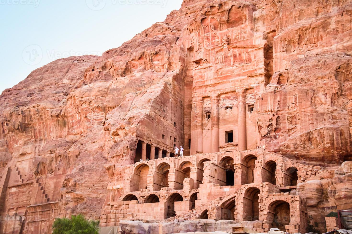 Tourist stand by Royal tombs structures in ancient city of Petra