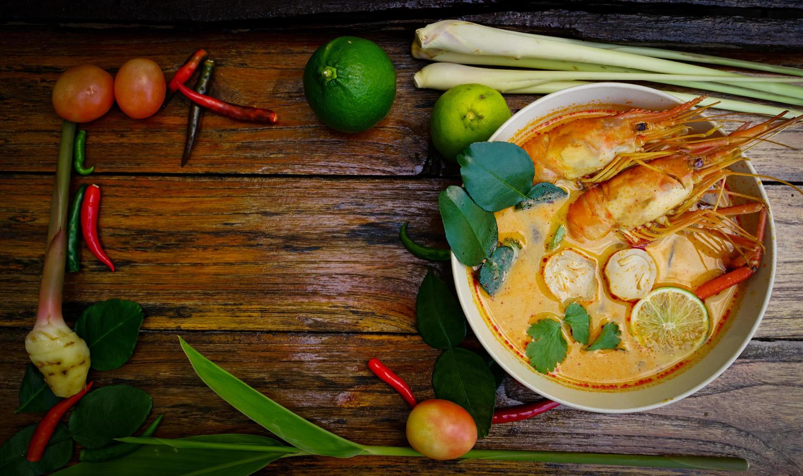 Tom yum kung in a cup on a wooden floor, Tom yum kung is also the national dish of Thailand.  And is a food that is famous all over the world. photo