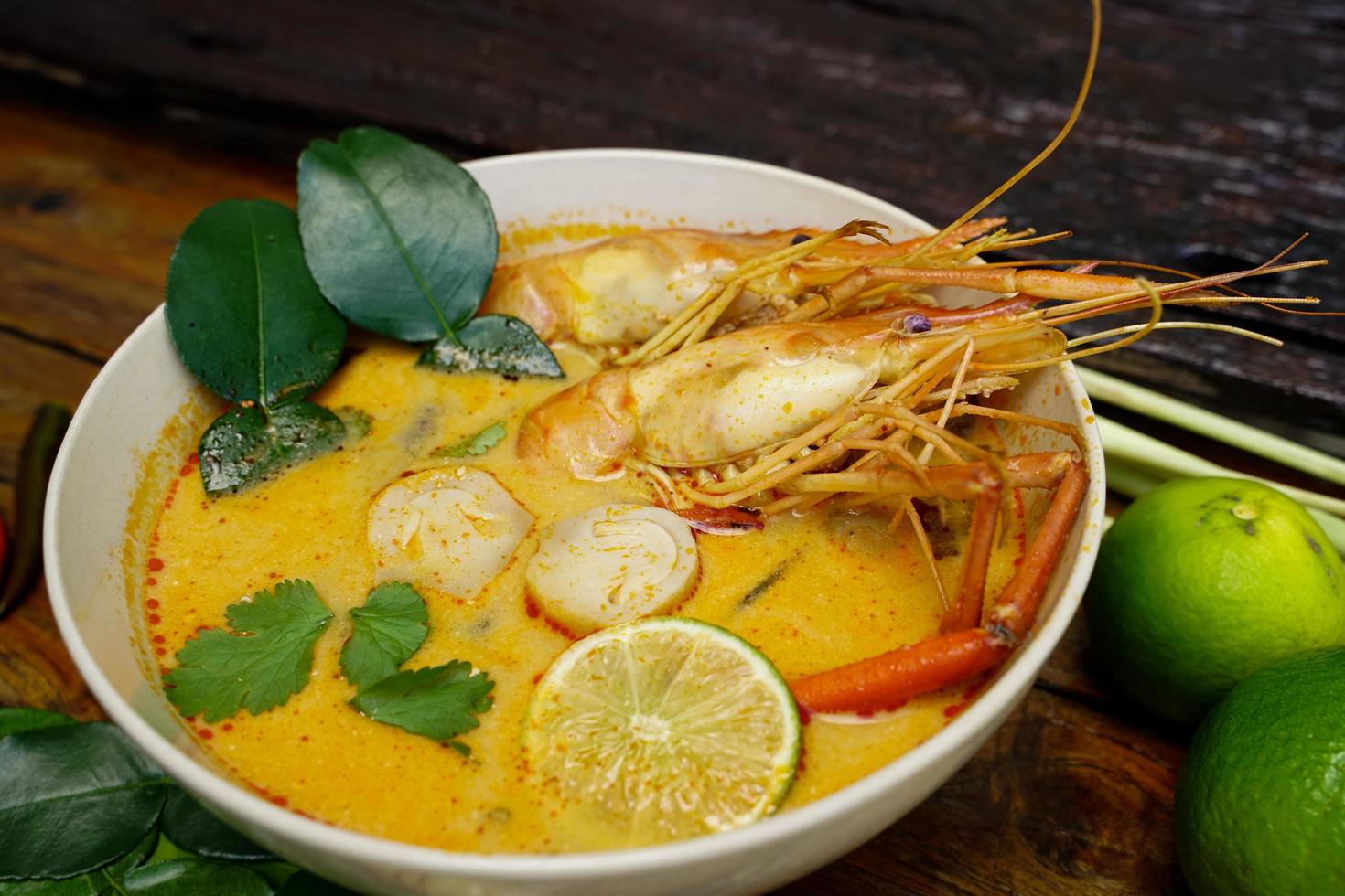 Tom yum kung in a cup on a wooden floor, Tom yum kung is also the national dish of Thailand.  And is a food that is famous all over the world. photo