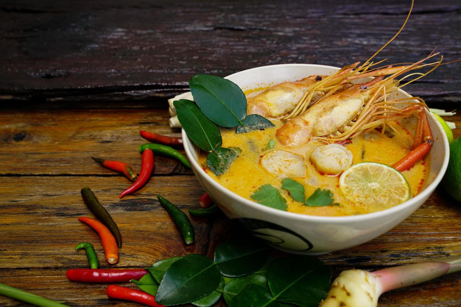 Tom yum kung in a cup on a wooden floor, Tom yum kung is also the national dish of Thailand.  And is a food that is famous all over the world. photo