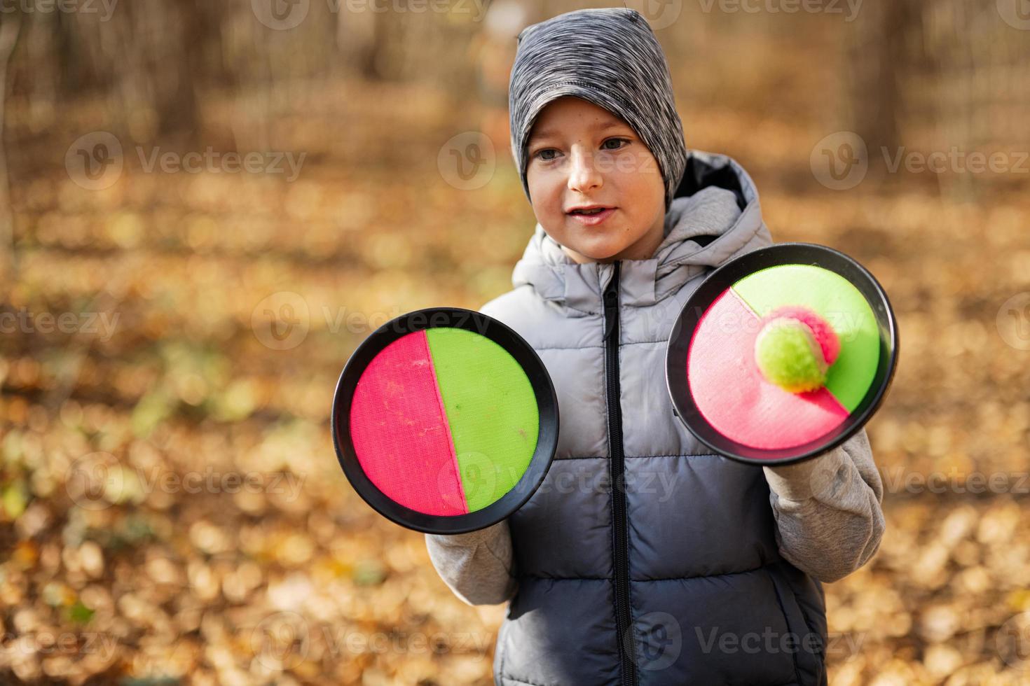 Autumn outdoor portrait of boy with catch and toss ball game. photo