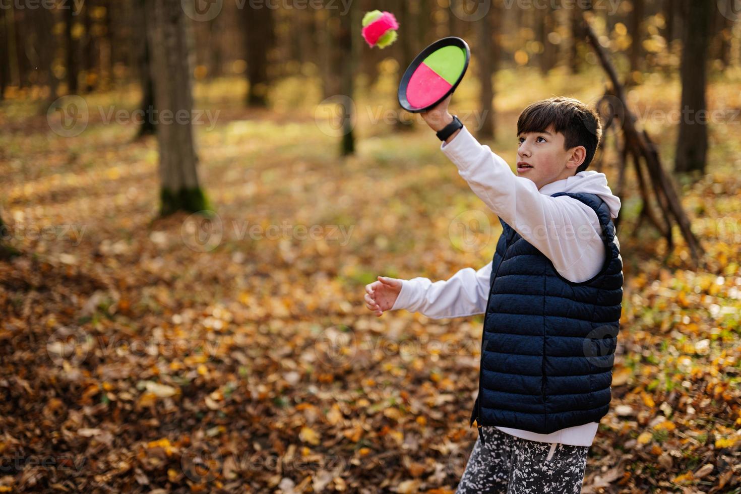 Autumn outdoor portrait of boy play with catch and toss ball game. photo