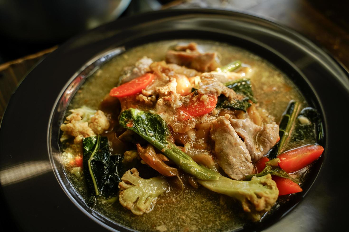 fideos salteados con carne de cerdo y col rizada en salsa La comida china y la comida tailandesa son populares en todo el país. foto