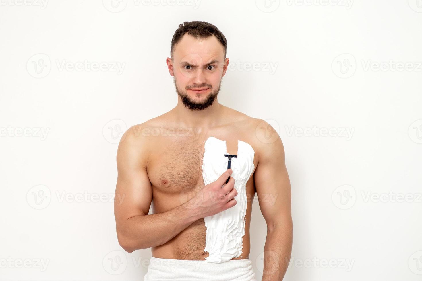 Young man shaving his chest photo