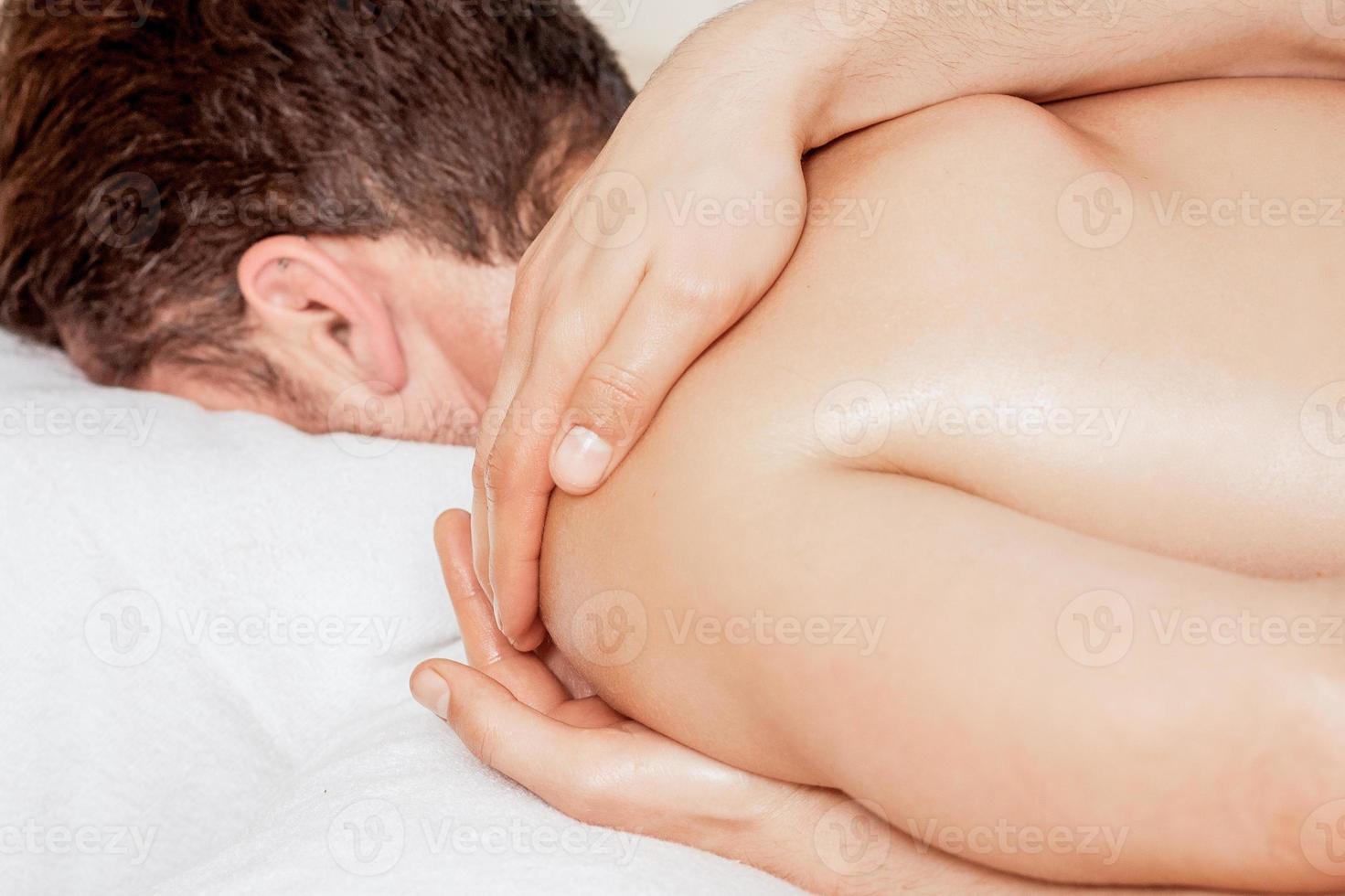 Man receiving massage on shoulder. photo