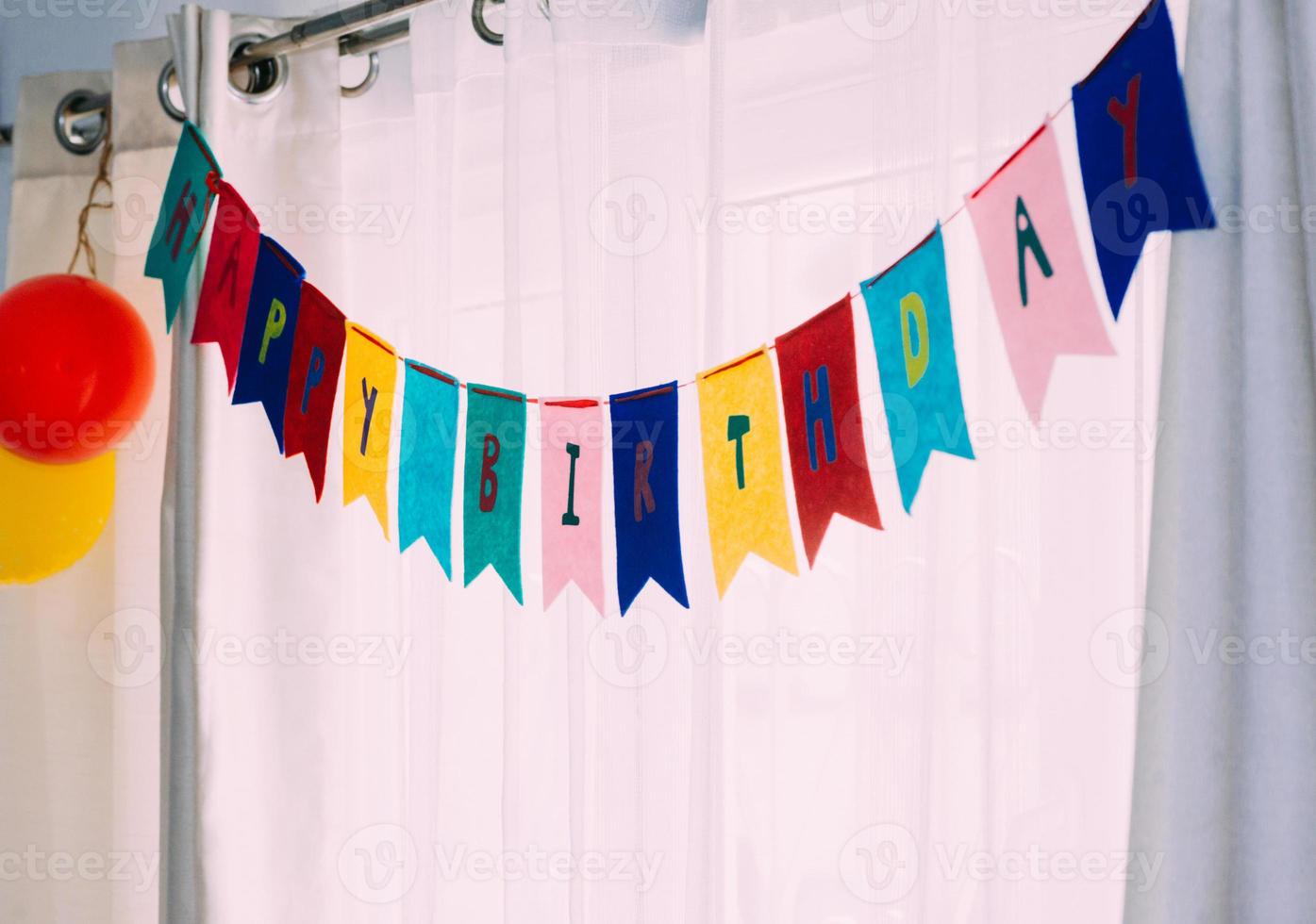 Happy birthday banner party background against white curtains and natural light photo
