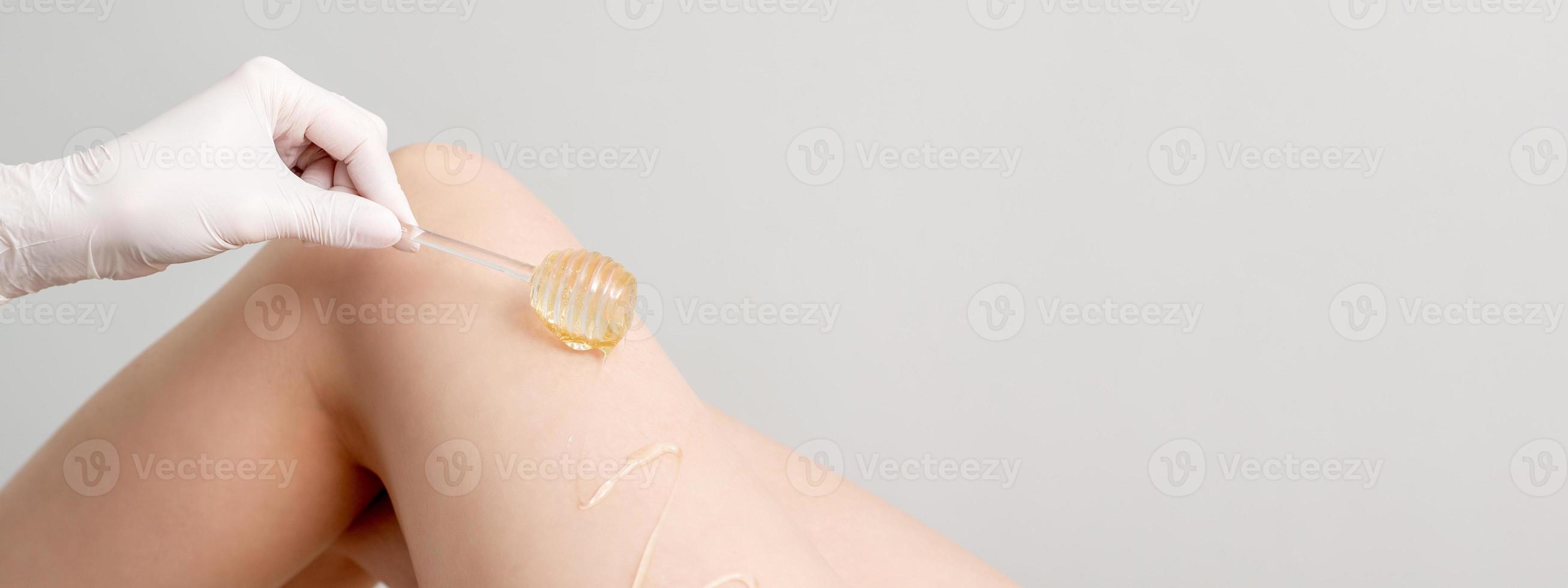 Wax flowing down on female leg photo