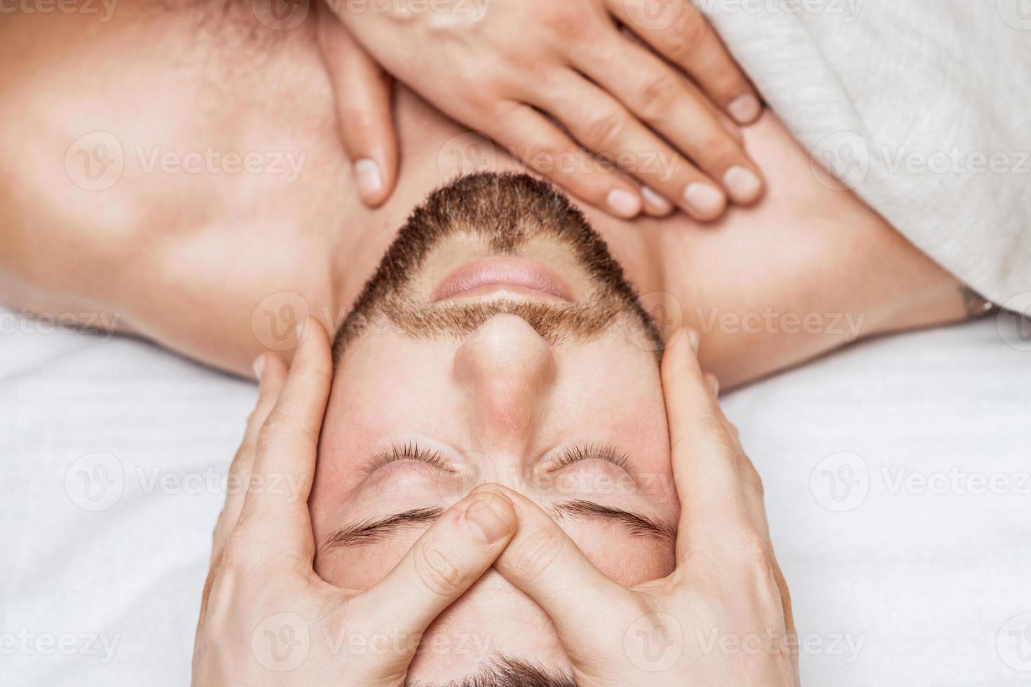 Young caucasian man enjoying head massage photo