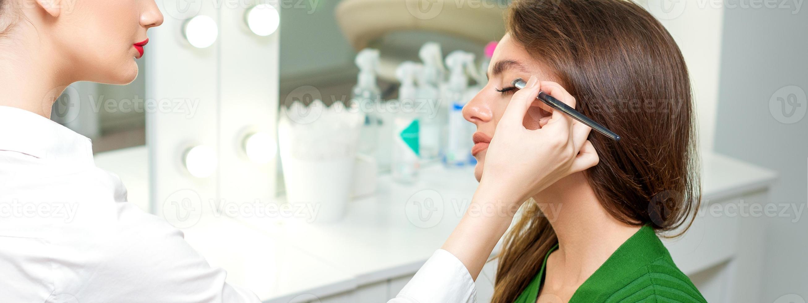 Makeup artist applies eyeshadow. photo