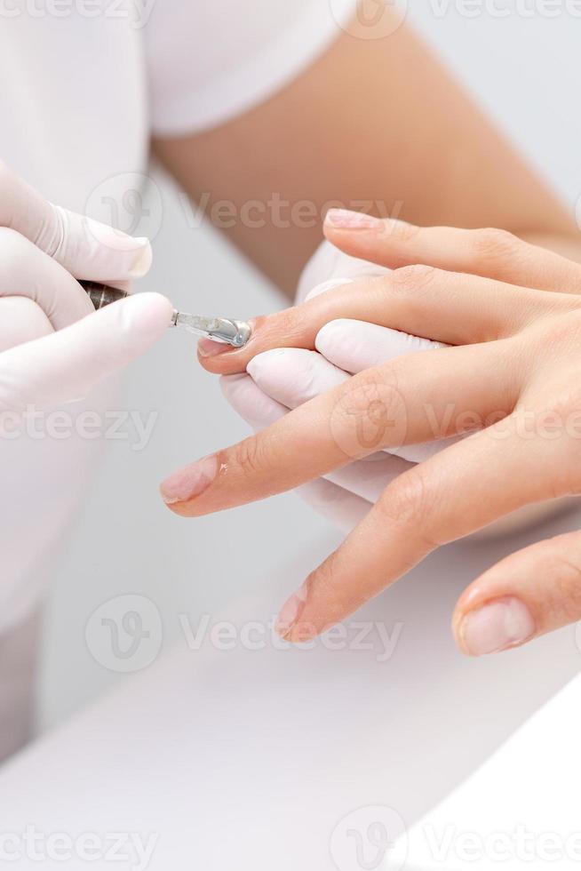 Woman receiving nail care procedure photo