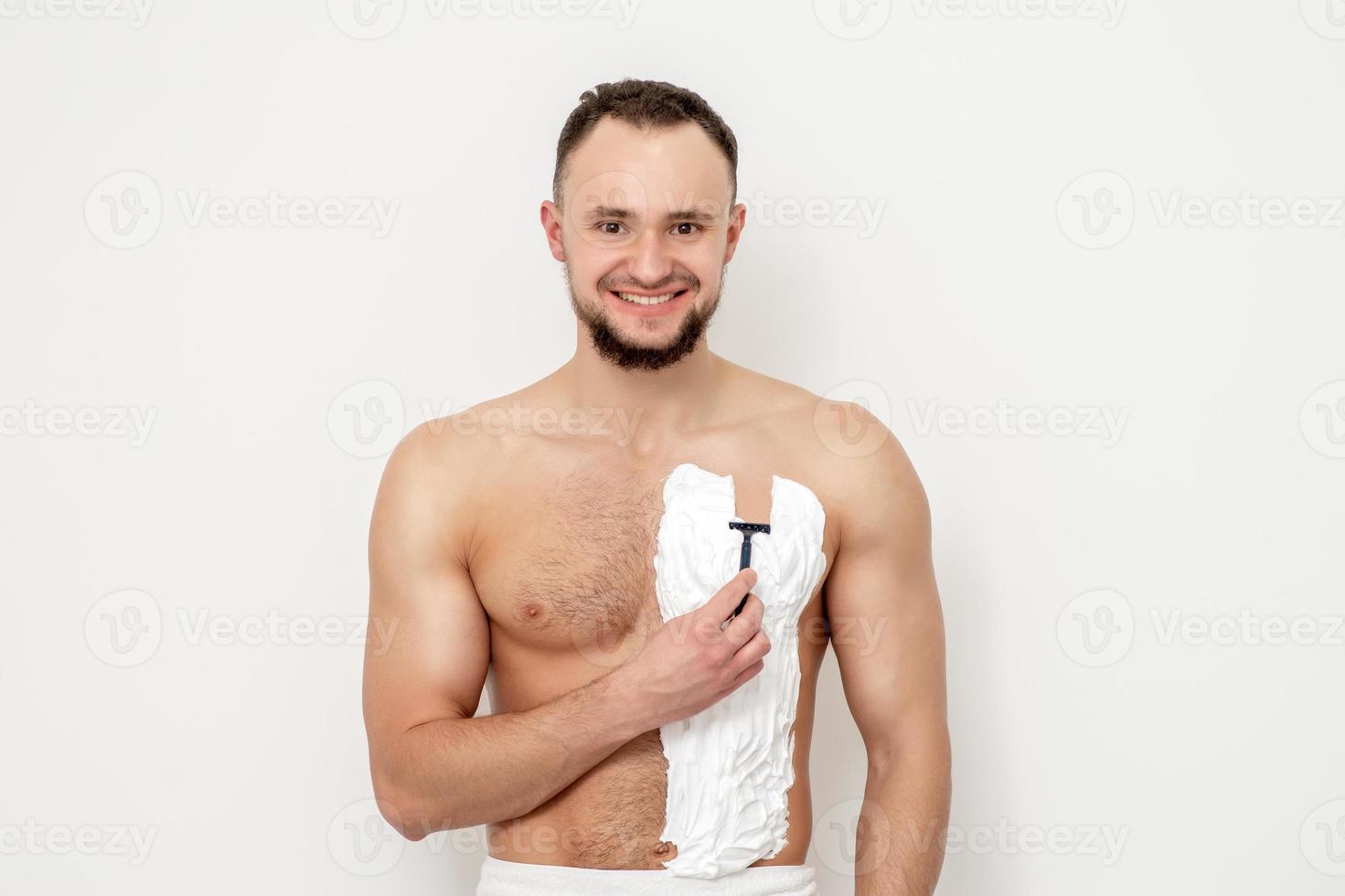 Young man shaving his chest photo