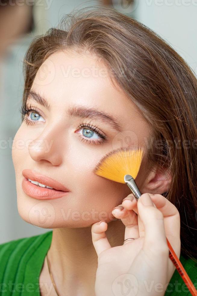 Professional make up artist applying powder photo