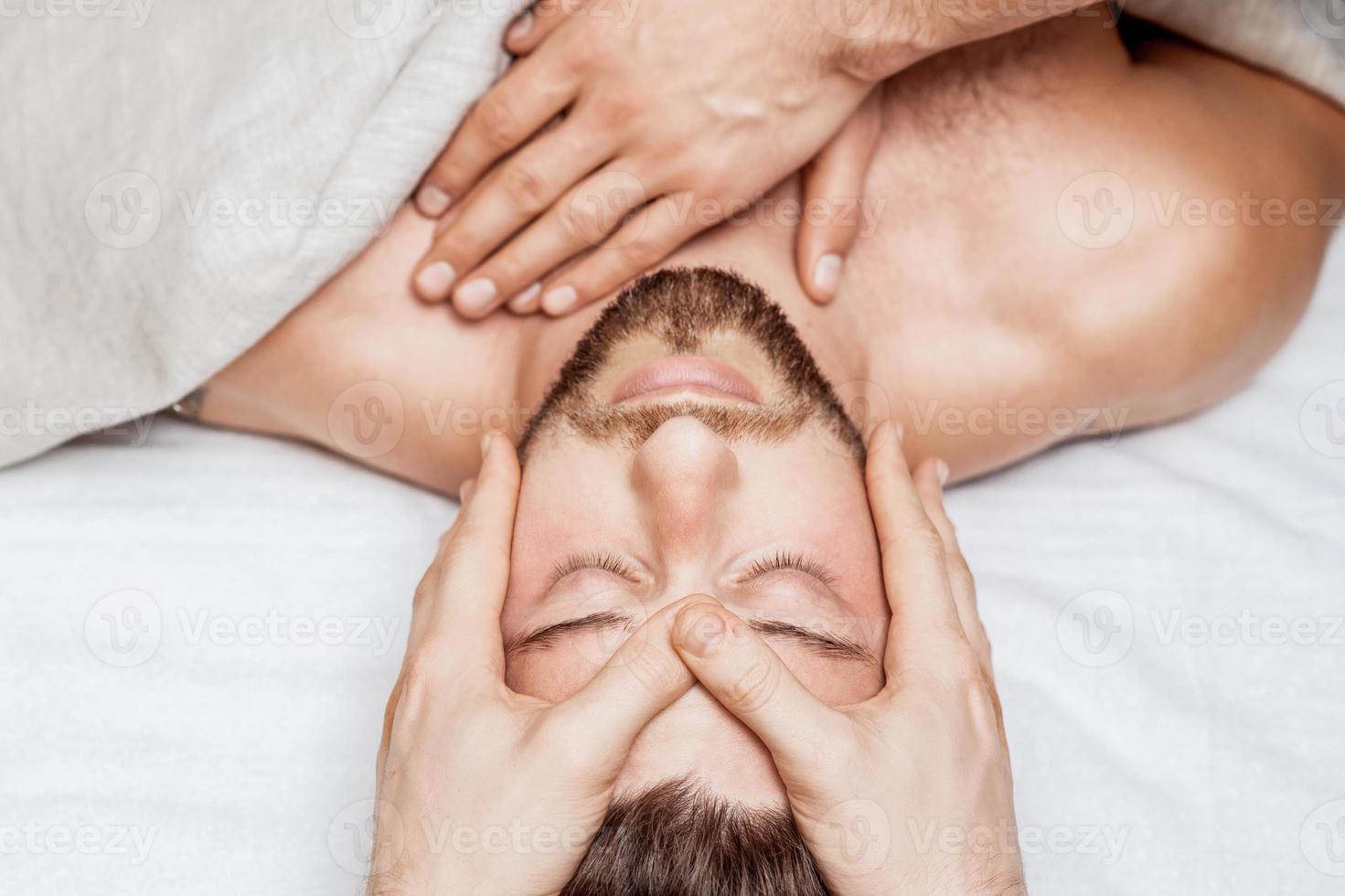 Young caucasian man enjoying head massage photo