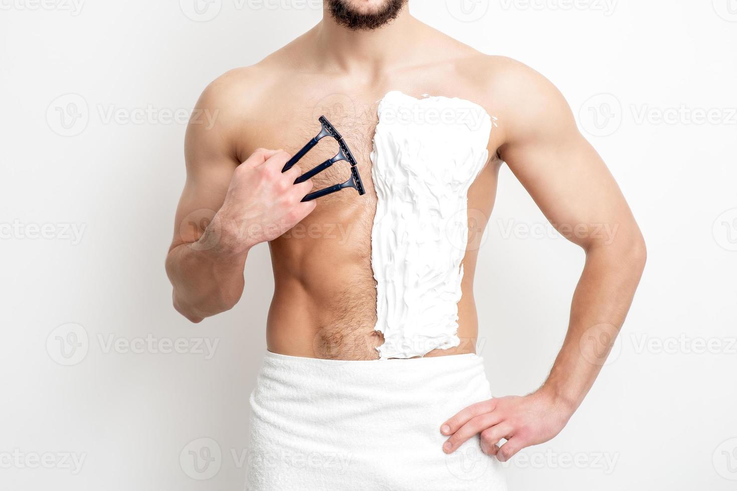 Young man shaving his chest photo