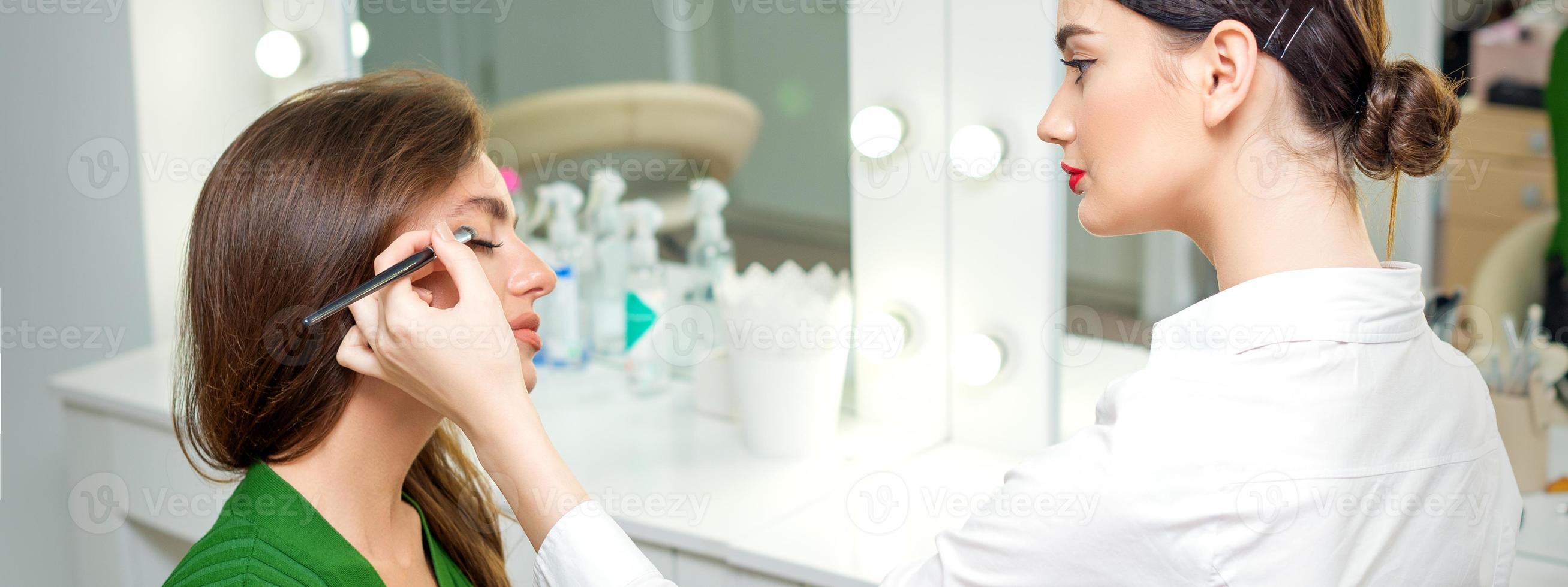 Makeup artist applies eyeshadow. photo