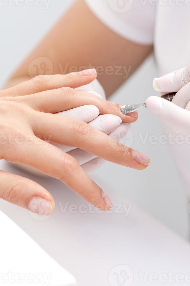 Woman receiving nail care procedure photo