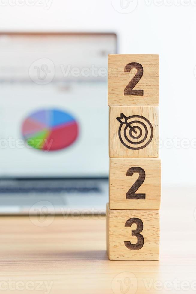 2023 Year block with dartboard icon against computer laptop background. Goal, Target, Resolution, strategy, plan, Action, mission, motivation, and New Year start concepts photo