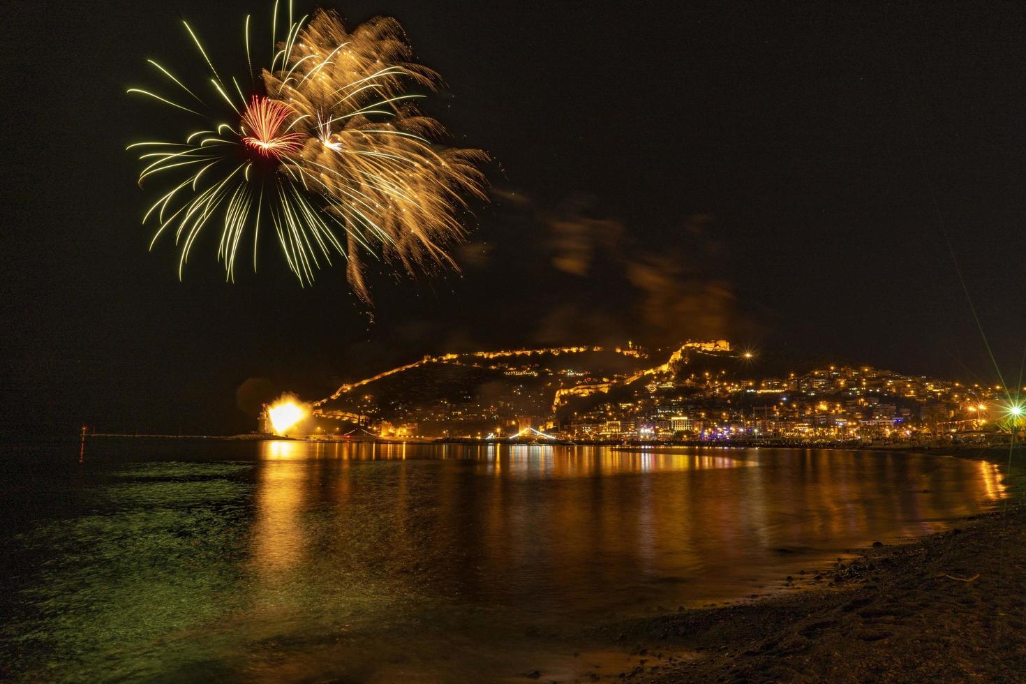 wonderful reflection of night fireworks on the sea and city sea view photo