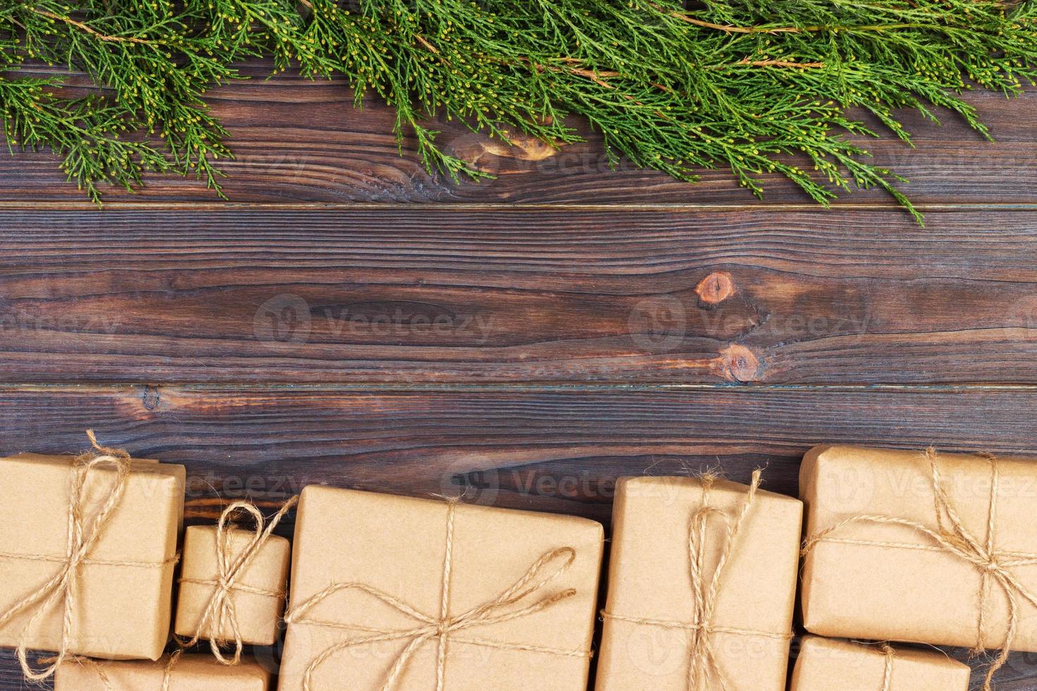 Christmas fir tree branches with gift box on dark rustic wooden background with copy space for text photo