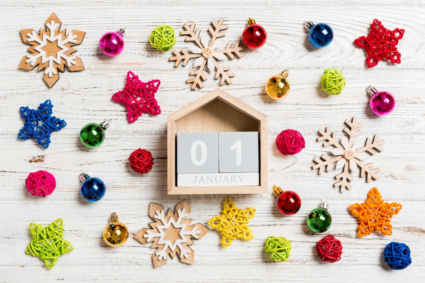 Top view of calendar on Christmas wooden background. The first of January. New Year toys and decorations. Holiday concept photo
