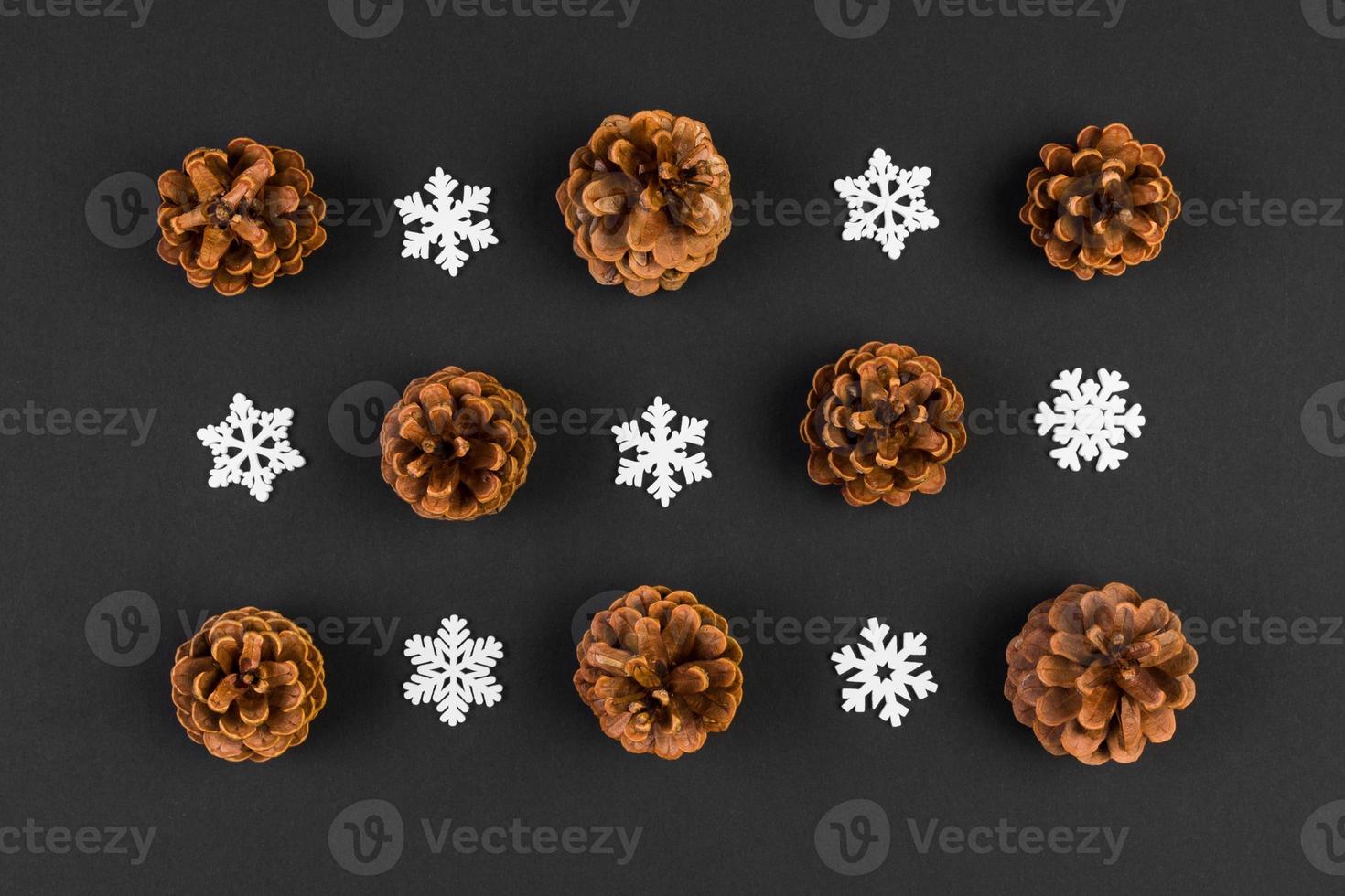 Top view of holiday composition made of pine cones and white snowflakes on colorful background. Winter time and Christmas concept with copy space photo