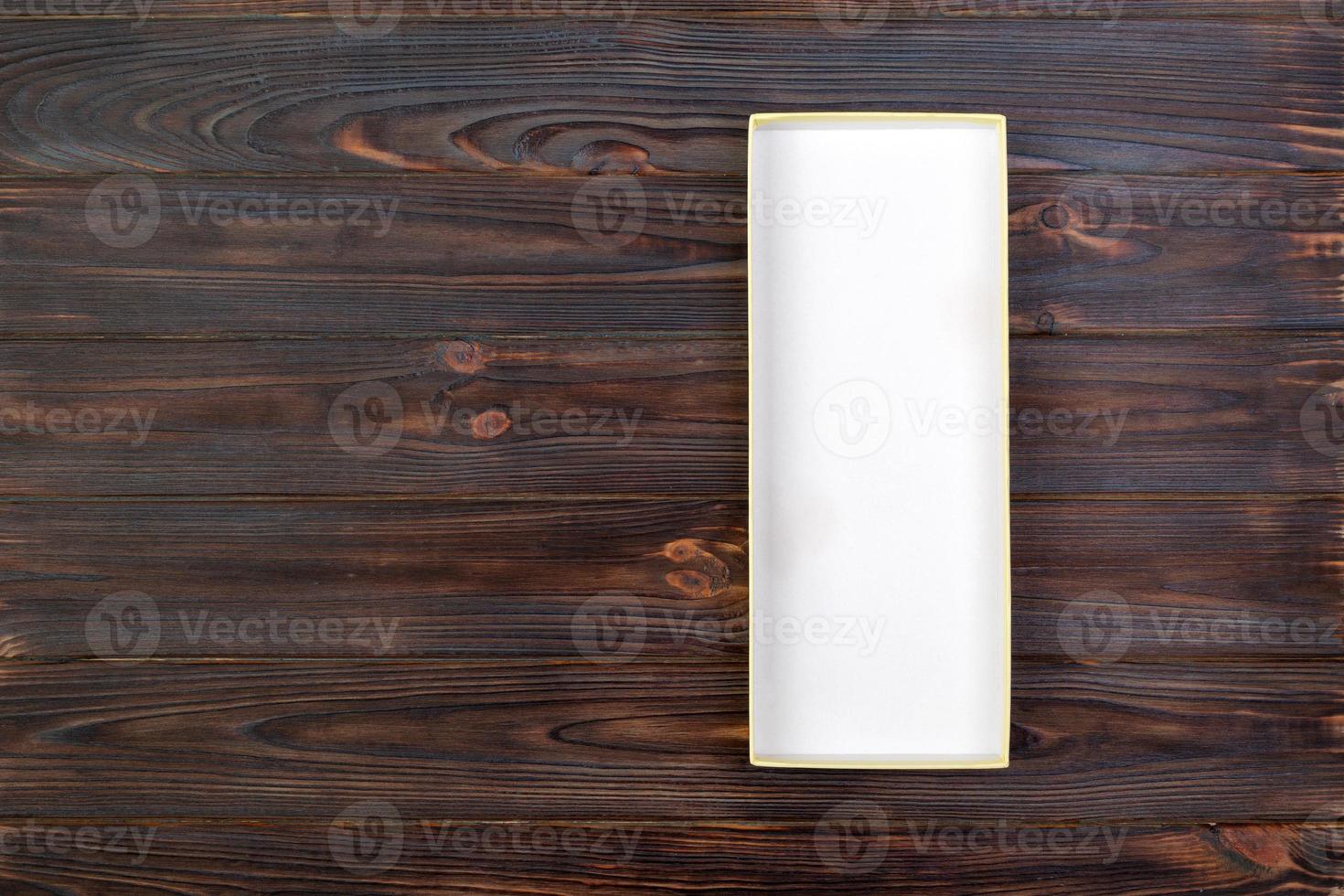 White rectangular empty open box, top view on dark wooden background. top view photo