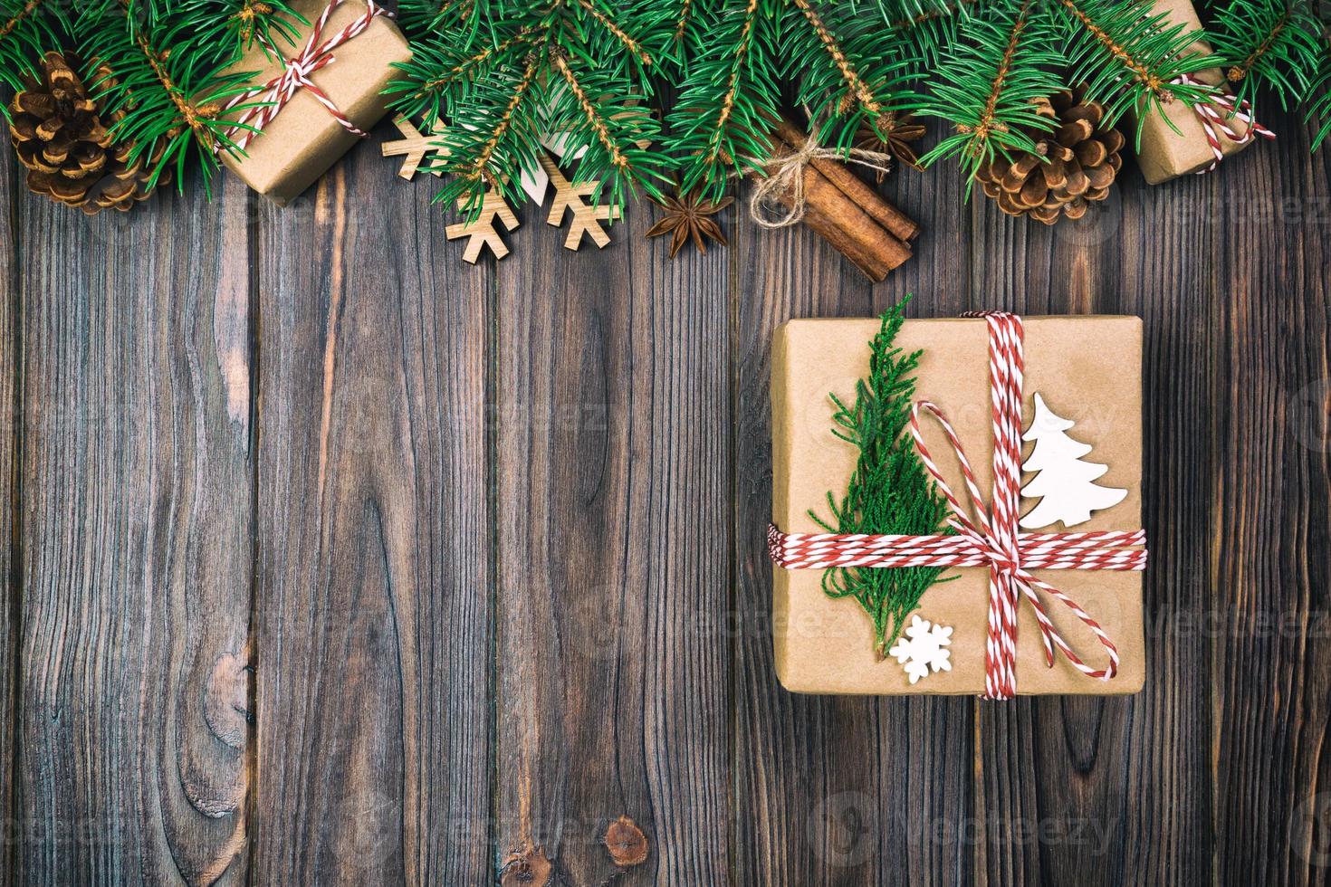 Christmas vintage, toned background with fir tree and gift box on wooden table. Top view with copy space for your design photo