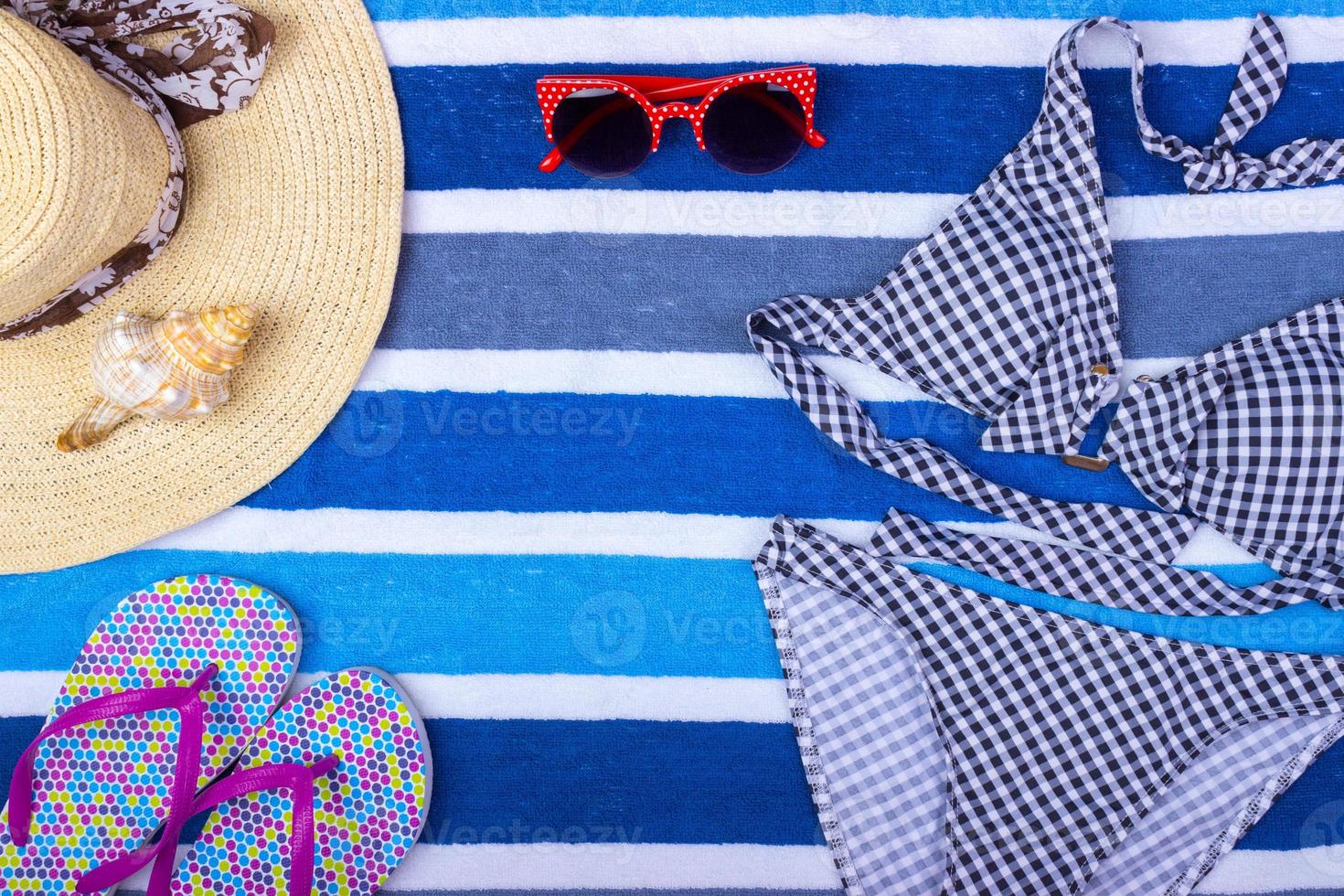 swimsuit with beach accessories on blue background. Sun Glasses Top View Seashell Shorts Flip flops Swimsuit photo