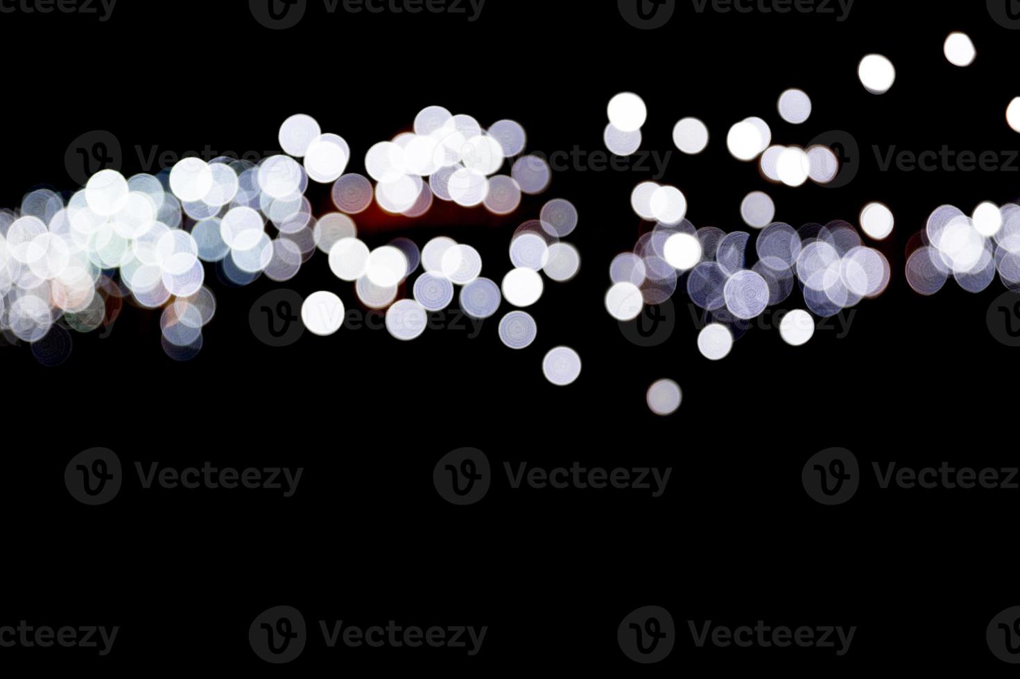 Abstract bokeh of white city lights on black background. defocused and blurred many round light photo