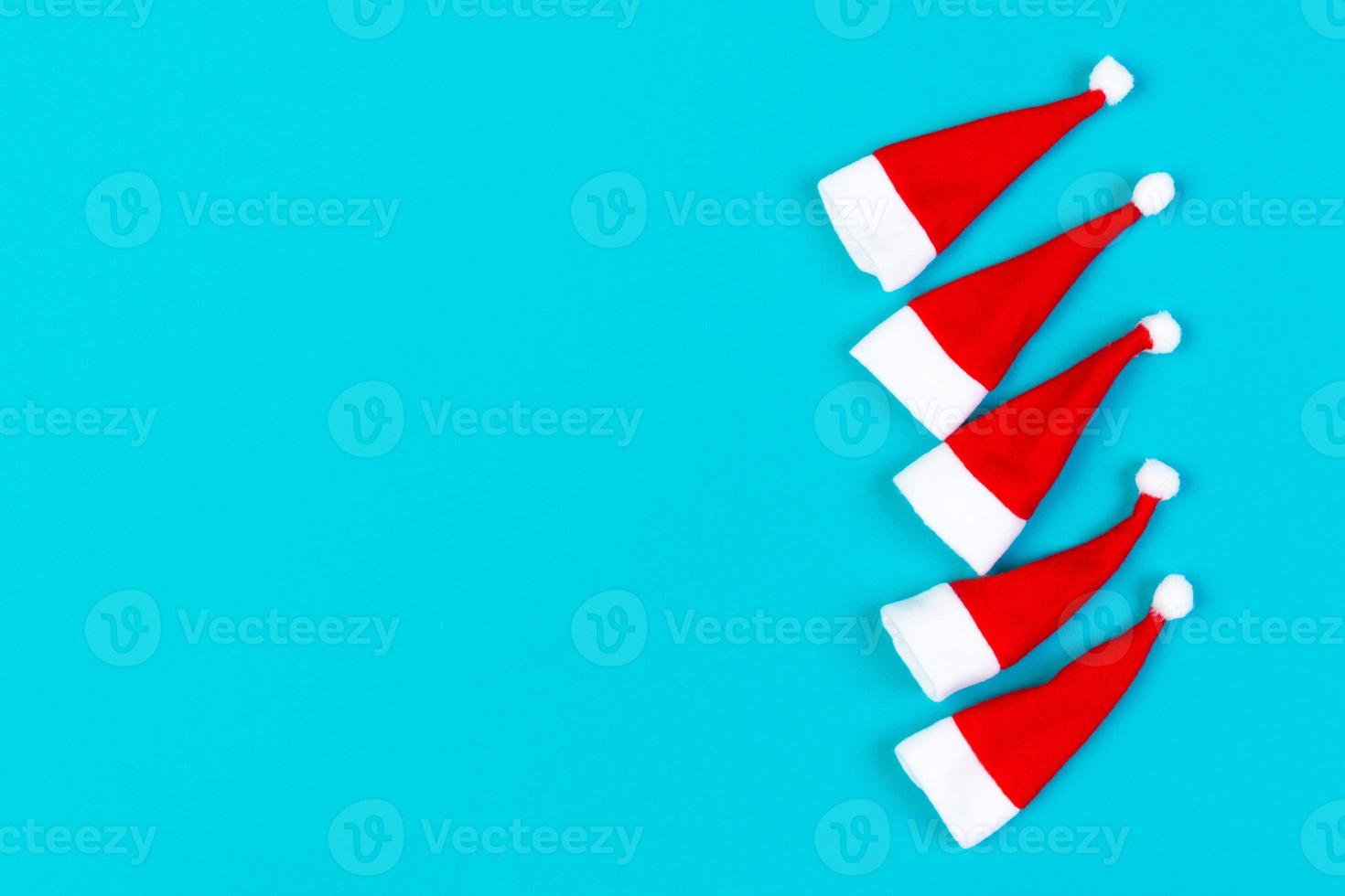 Top view od stylish red Santa hats on colorful background. Merry Christmas concept with copy space photo